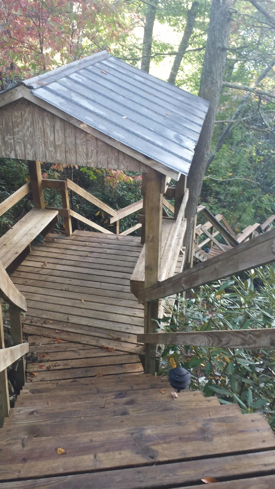 Metal roofed shelter over wooden steps on a wooded walkway — Skylight Repair & Installation work by our crew in Poestenkill