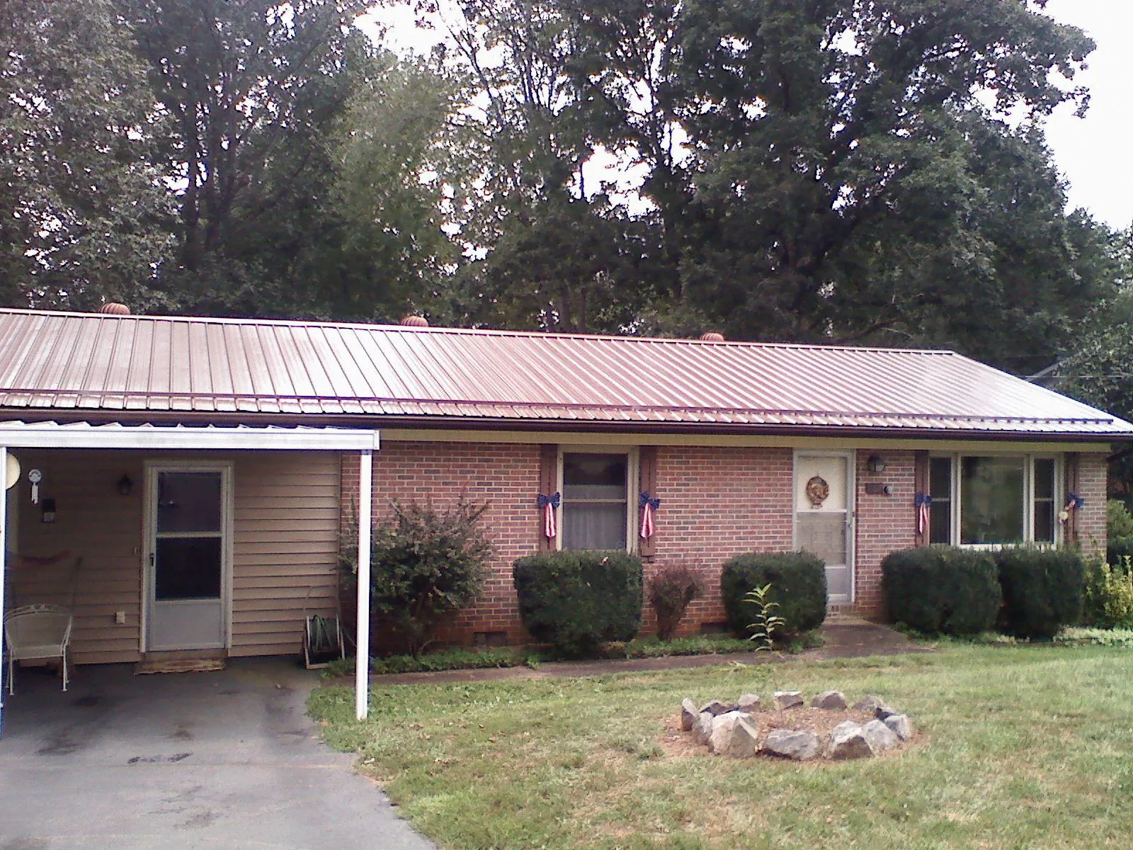 Bronze metal roof and carport on a brick ranch home — Roof Repair work by our crew in Poestenkill